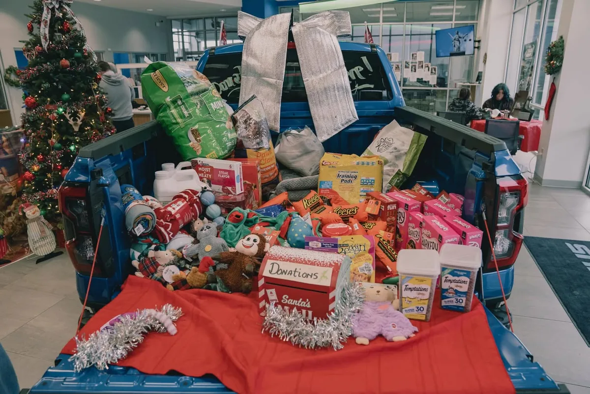 A truck bed filled with donated pet food, toys, and supplies at Pettus Ford De Soto