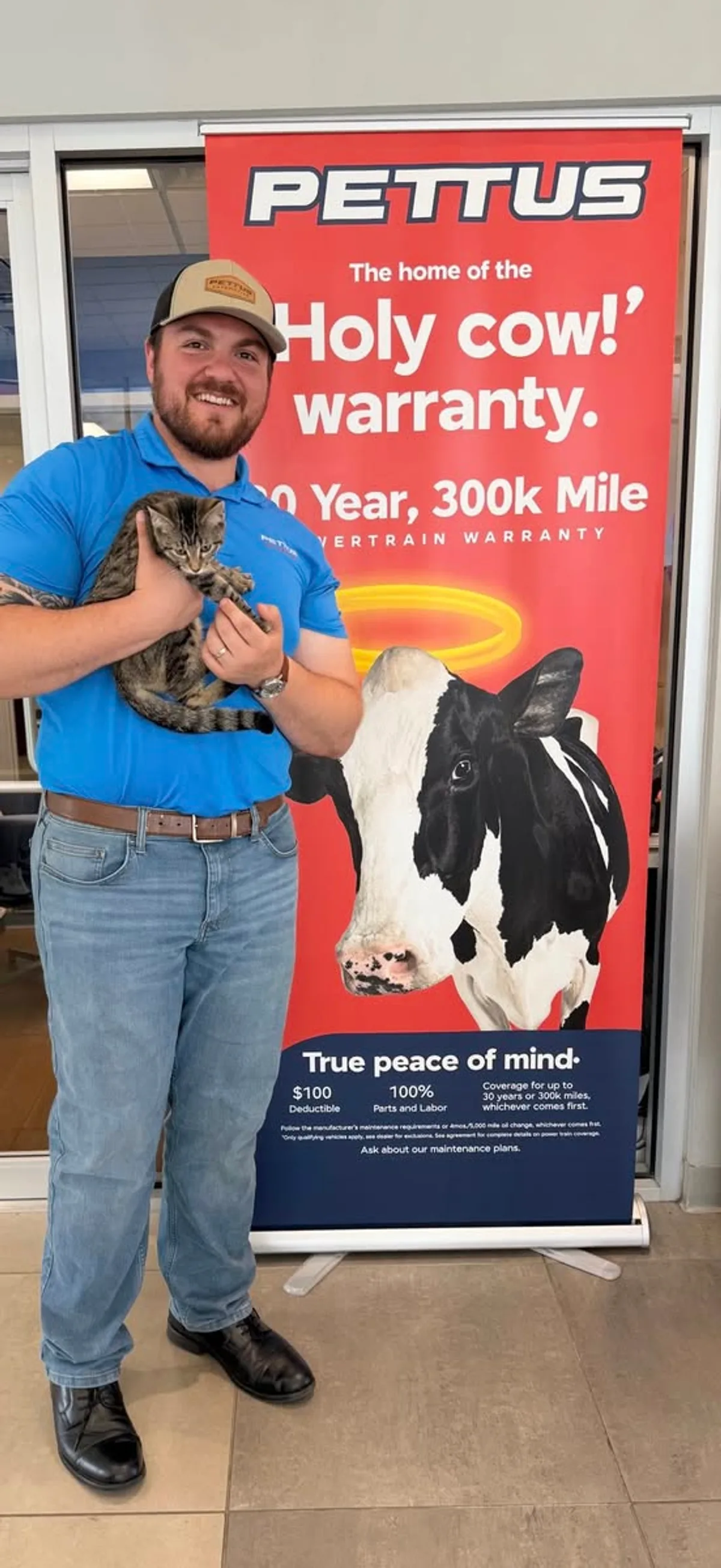 A Pettus Ford De Soto team member holding a kitten during a Waggin' Wednesday visit