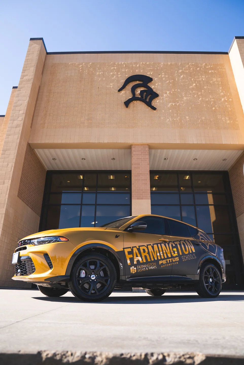 Custom-wrapped Dodge Hornet for Farmington R-7 Schools outside the school building