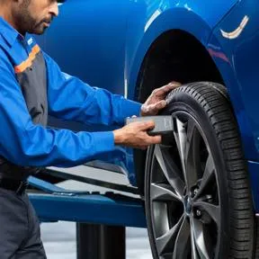 Quick Lane technician inspecting and servicing a tire